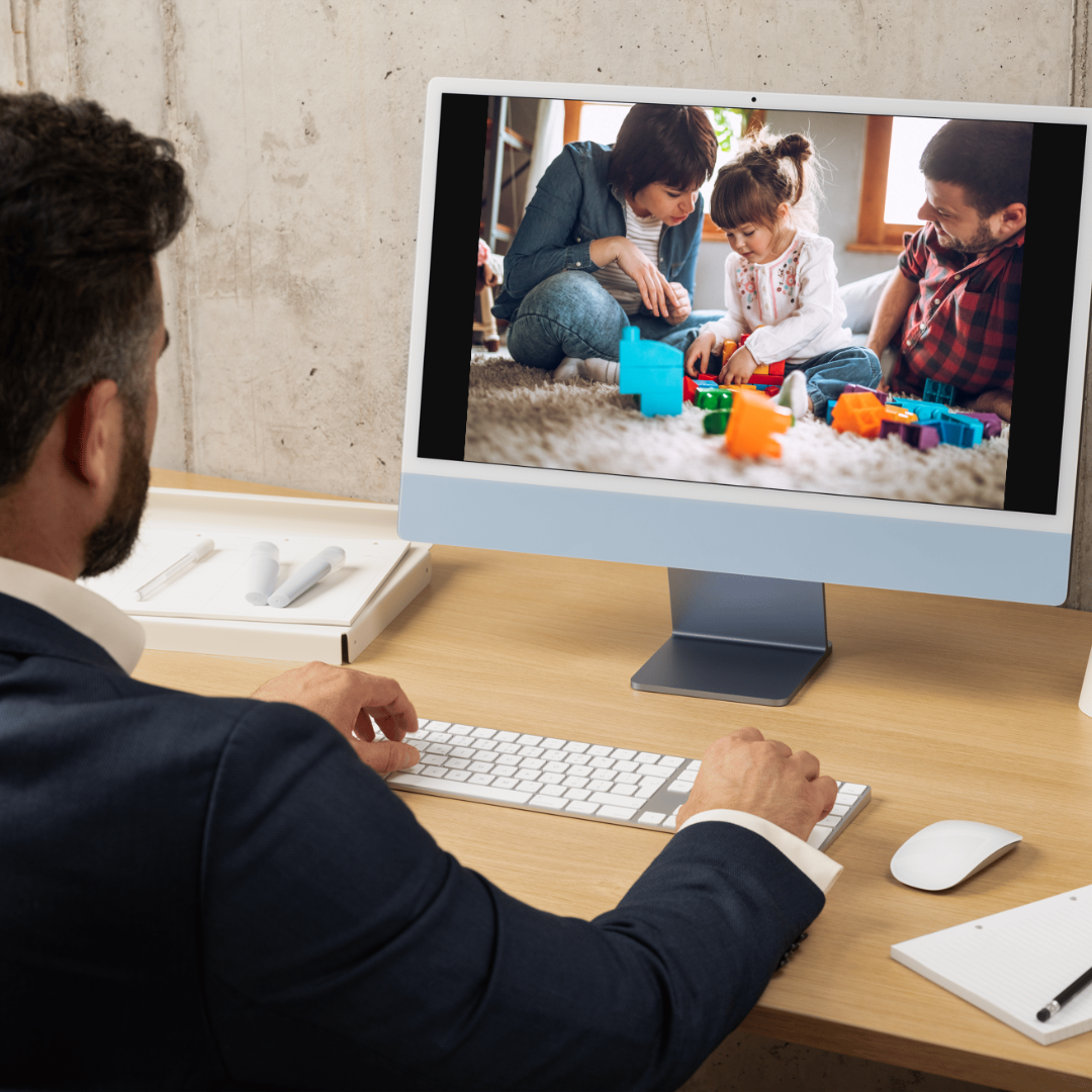 Hombre viendo en la computadora un video de unos padres jugando con su hija